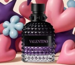 Tre flaconi di profumo da uomo Valentino Uomo Born in Roma su uno sfondo a righe